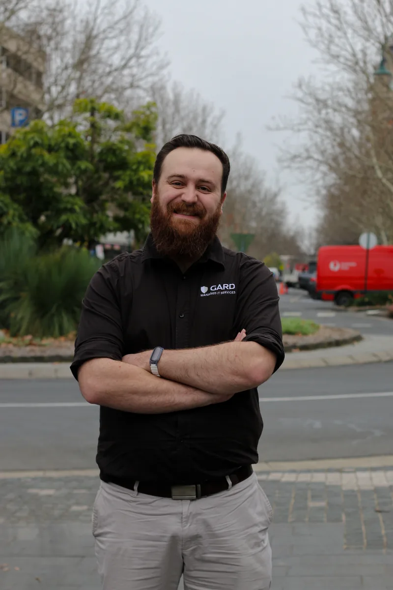 Carl from GARD Systems standing on a Bendigo street, arms folded, wearing a branded GARD shirt