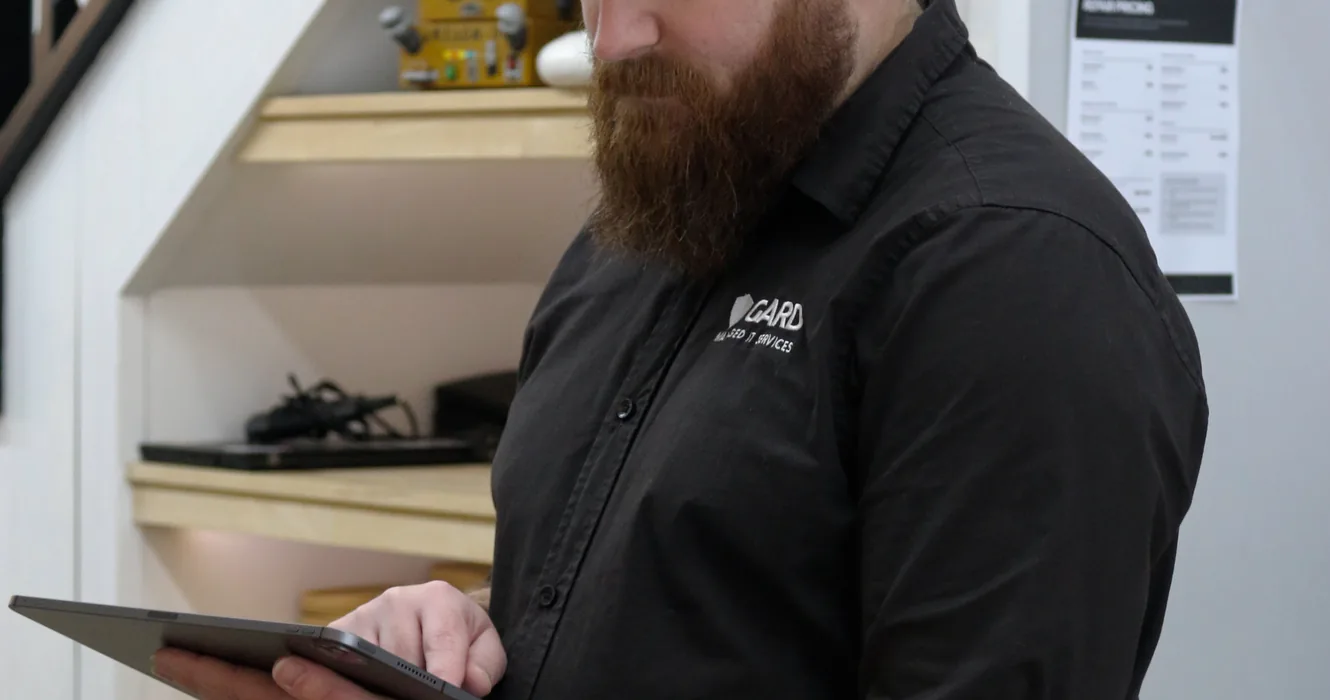 Carl from GARD Systems reviewing a client site on a tablet in the workshop